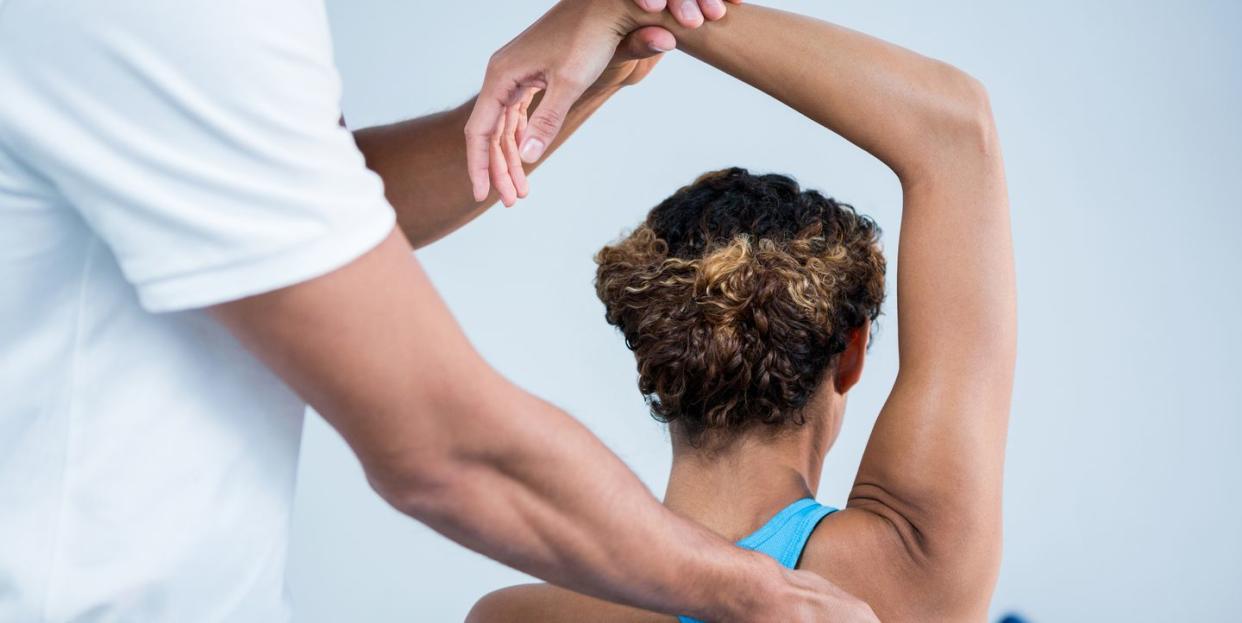 physiotherapist giving shoulder therapy to a woman