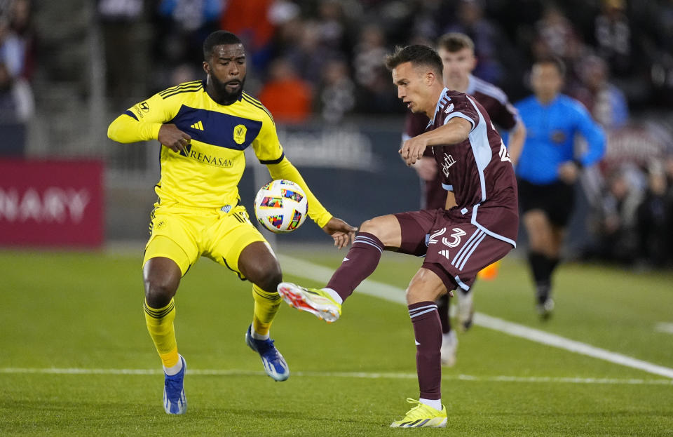 Colorado Rapids midfielder Cole Bassett, right, kicks the ball as Nashville SC defender Shaq Moore, left, covers during the first half of an MLS soccer match Saturday, March 2, 2024, in Commerce City, Colo. (AP Photo/David Zalubowski)