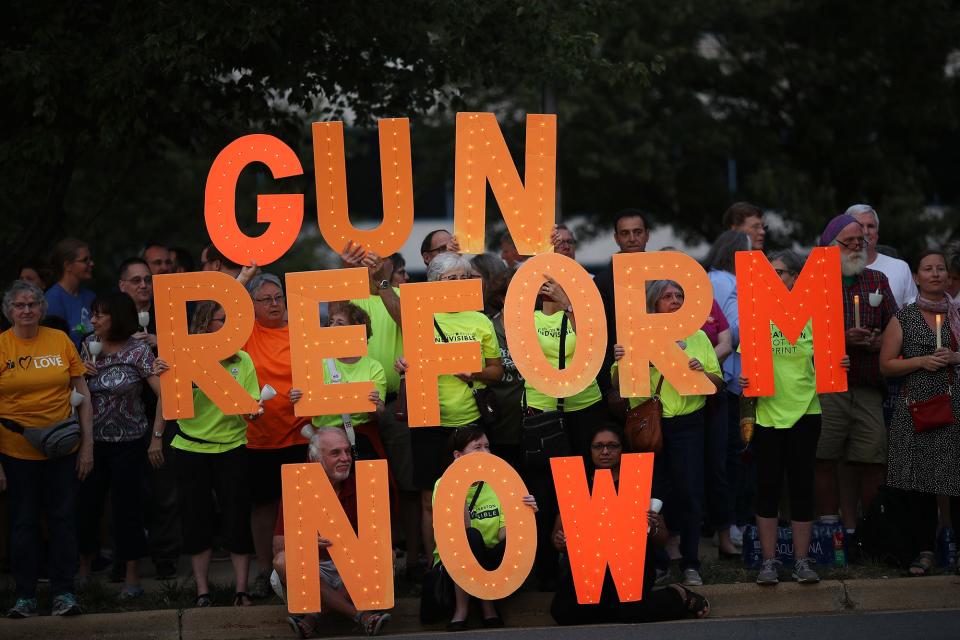 Advocates of gun reform legislation hold a candle light vigil for victims of recent mass shootings outside the headquarters of the National Rifle Association on Aug. 5, 2019, in Fairfax, Va. Thirty-one people have died following the two mass shootings over the weekend in El Paso, Texas, and Dayton, Ohio.