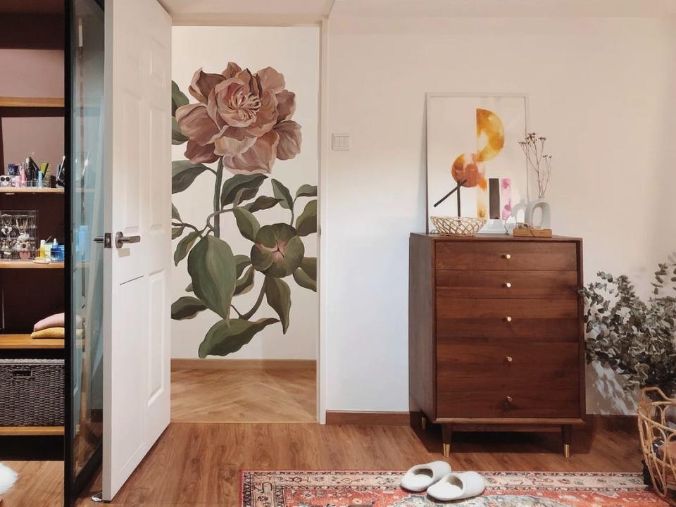 A mural painting of a rose on a corridor wall fits nicely within the doorframe when viewed from the bedroom.