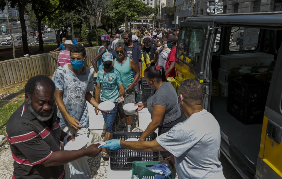 Moradores de rua recebem almoço no centro de São Paulo, Brasil, em 23 de março de 2021. - A Prefeitura de São Paulo entrega cerca de 7.500 almoços por dia após aumento considerável de moradores de rua em meio à pandemia de coronavírus