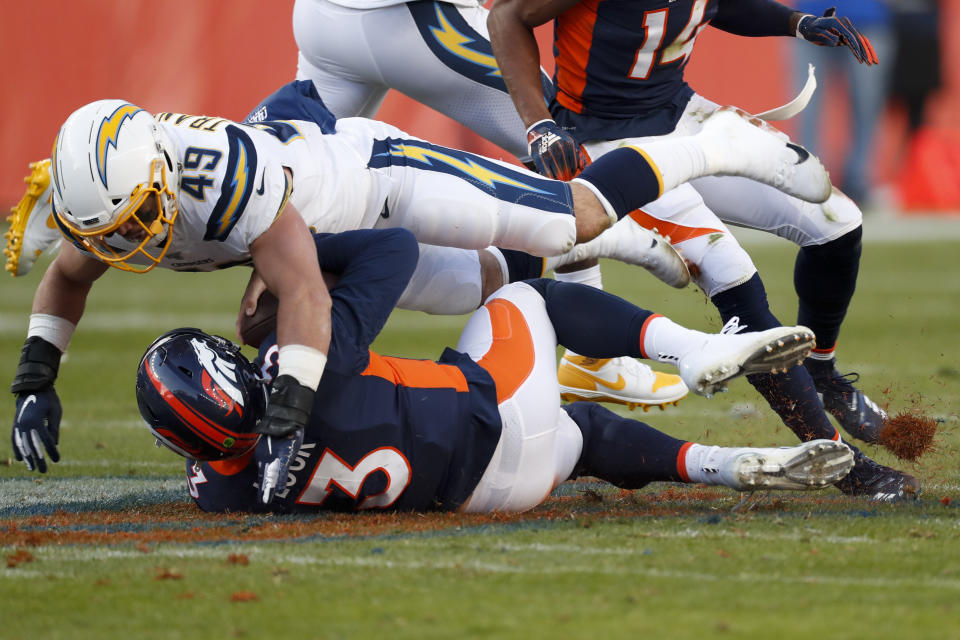 Denver Broncos quarterback Drew Lock is tackled by Los Angeles Chargers linebacker Drue Tranquill during the first half of an NFL football game Sunday, Dec. 1, 2019, in Denver. (AP Photo/David Zalubowski)