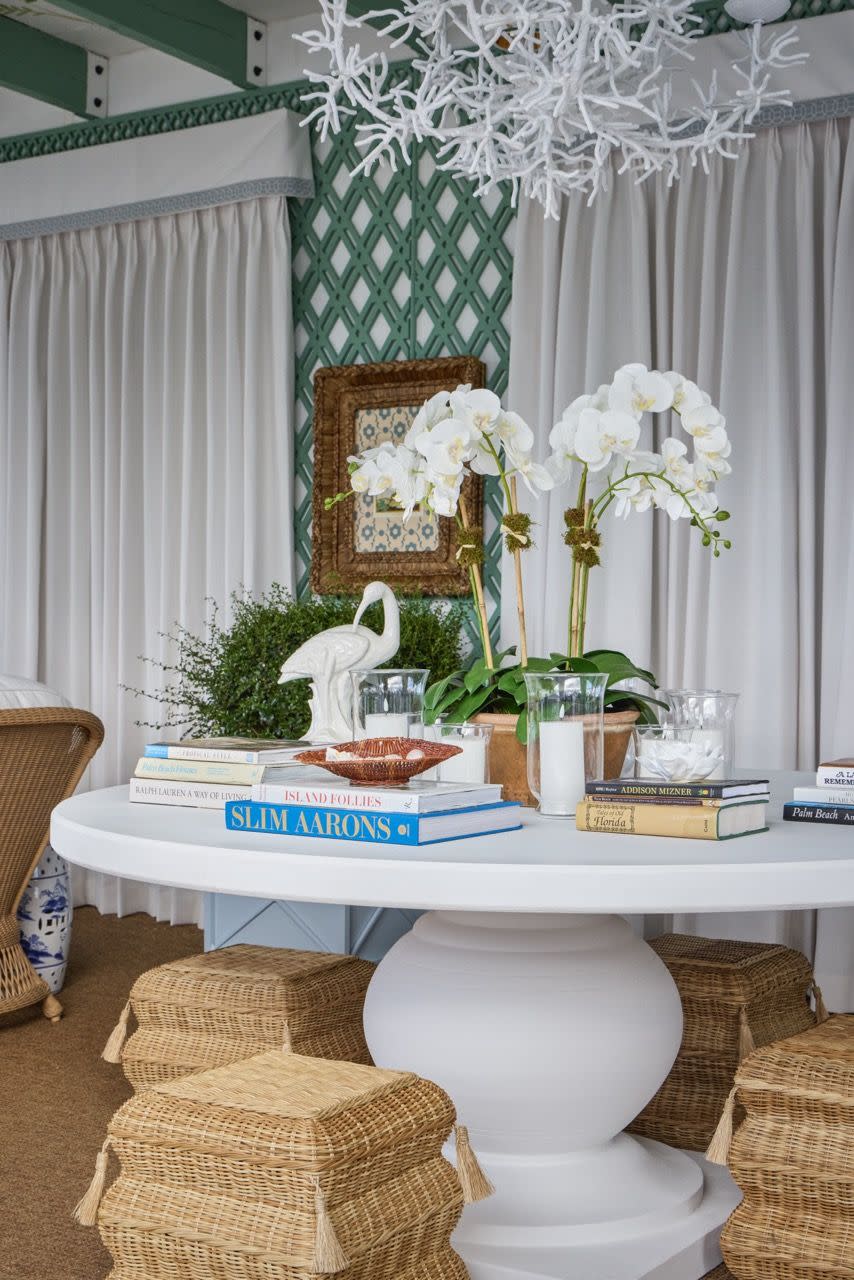 a table with a vase of flowers and a basket of books