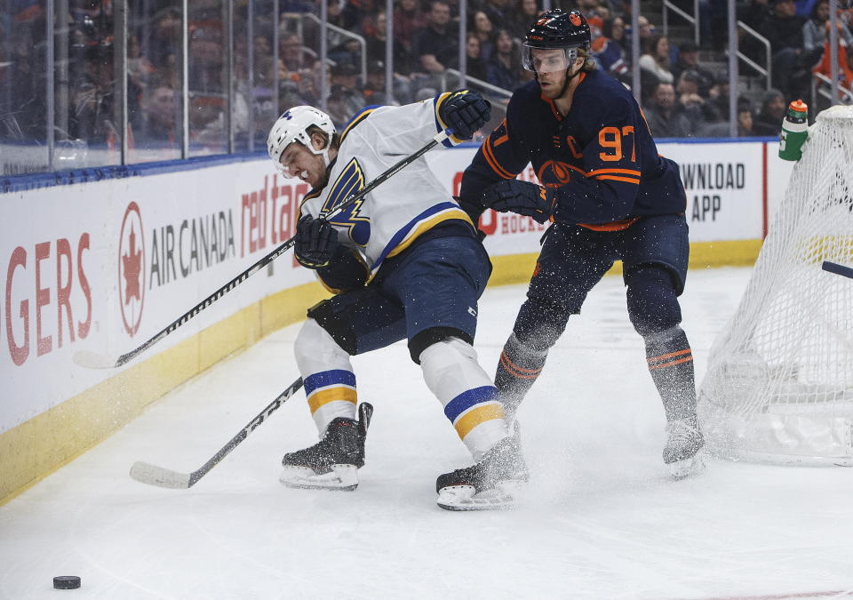 St. Louis Blues' Robert Thomas (18) and Edmonton Oilers' Connor McDavid (97) vie for the puck during the first period of an NHL hockey game Friday, Jan. 31, 2020, in Edmonton, Alberta. (Jason Franson/The Canadian Press via AP)