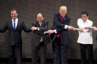 <p>U.S. President Donald Trump, second from right, reacts as he does the “ASEAN-way handshake” with Russian Prime Minister Dmitry Medvedev, left, Vietnamese Prime Minister Nguyen Xuan Phuc, second from left, and Philippine President Rodrigo Duterte on stage during the opening ceremony at the ASEAN Summit at the Cultural Center of the Philippines, Nov. 13, 2017, in Manila, Philippines. Trump initially did the handshake incorrectly. Trump is on a five-country trip through Asia traveling to Japan, South Korea, China, Vietnam and the Philippines. (Photo: Andrew Harnik/AP) </p>