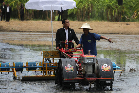 FILE PHOTO: Thailand's Prime Minister Prayuth Chan-ocha rides on a tractor at a farmer school in Suphan Buri province, Thailand, September 18, 2017. REUTERS/Athit Perawongmetha/File Photo