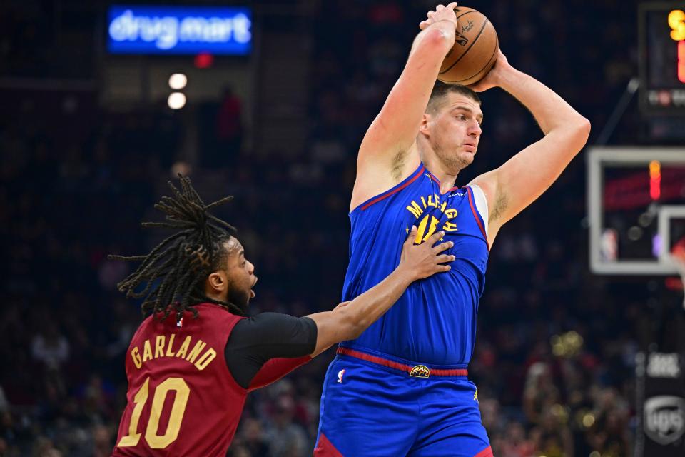 Denver Nuggets center Nikola Jokic is pressured by Cleveland Cavaliers guard Darius Garland in the first half of an NBA basketball game, Sunday, Nov. 19, 2023, in Cleveland. (AP Photo/David Dermer)