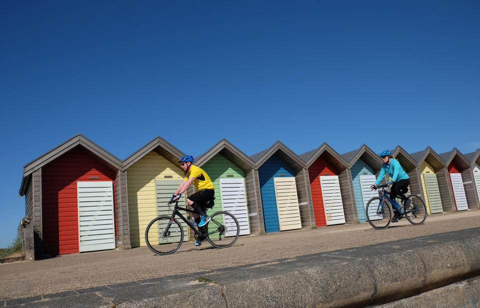 Cyclists ride under a clear blue sky in Blyth, Northumberland, as highs of 22C are now expected for some parts of the UK by the weekend.