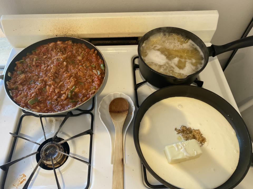 the two pans and pot on the stove