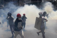 Anti-coup protesters run away from tear gas launched by security forces in Yangon, Myanmar, Monday, March 1, 2021. Defiant crowds returned to the streets of Myanmar's biggest city on Monday, determined to continue their protests against the military's seizure of power a month ago, despite security forces having killed at least 18 people around the country just a day earlier. (AP Photo)