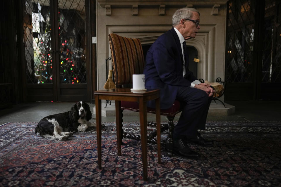 Ohio Gov. Mike DeWine speaks as his dog Dolly stays close by during an interview with The Associated Press at the Ohio Governor's Residence in Columbus, Ohio, Thursday, Dec. 21, 2023. (AP Photo/Carolyn Kaster)