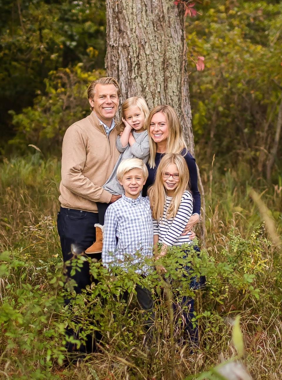 Abby Adair Reinhard, her husband Josh, and their three kids pose for a family photo in summer 2020.