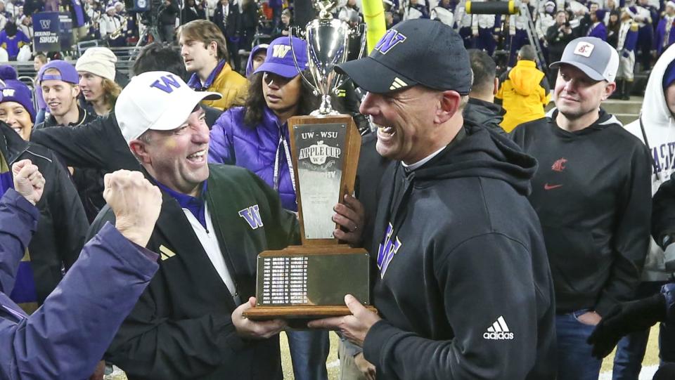 SEATTLE, WA - November 25:  Washington head coach Kalen DeBoer holds the Apple cup trophy with Athletic Department AD Troy Dannen after the 115 Apple Cup college football game between the Washington Huskies and the Washington State Cougars on November 25, 2023, at Husky Stadium in Seattle, WA. (Photo by Jesse Beals/Icon Sportswire via Getty Images)