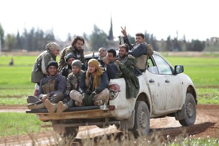 Rebel fighters from 'Jaysh al-Sunna' gesture as they ride a vehicle in Tel Mamo village, in the southern countryside of Aleppo, Syria March 6, 2016. REUTERS/Khalil Ashawi