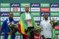 From left, Second-placed Titus Ekiru of Kenya, winner Uma Mulugeta of Ethiopia and third-placed Elisha Rotich of Kenya pose on the podium during the Paris marathon, in Paris, Sunday, April 7, 2024. (AP Photo/Lewis Joly)