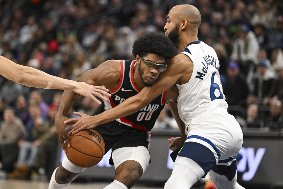 Portland Trail Blazers guard Scoot Henderson, left, is fouled by Minnesota Timberwolves guard Jordan McLaughlin, right, during the second half of an NBA basketball game Friday, Jan. 12, 2024, in Minneapolis. (AP Photo/Craig Lassig)