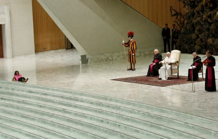 Pope Francis allows a little girl suffering from an undisclosed illness to move around undisturbed clapping and dancing on the stage for most of his general audience in Paul VI Hall at the Vatican