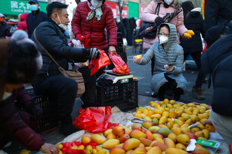 A customer buys mongo at a market in Shenyang, in China's eastern Liaoning province on December 9, 2022. - China OUT (Photo by AFP) / China OUT (Photo by STR/AFP via Getty Images)