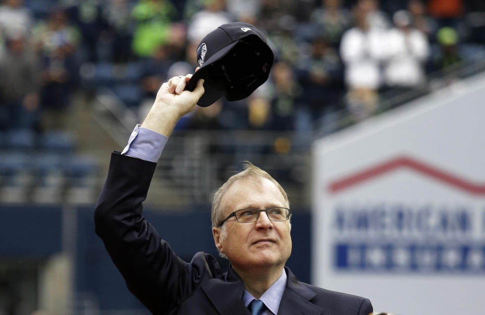 In this Sept. 17, 2017 photo, Seattle Seahawks owner Paul Allen waves as he is honored for his 20 years of team ownership before an NFL football game against the San Francisco 49ers in Seattle. Allen, who co-founded Microsoft with his childhood friend Bill Gates before becoming a billionaire philanthropist who invested in conservation, space travel, arts and culture and professional sports, died Monday. He was 65. (AP Photo/Elaine Thompson)