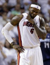 Miami Heat's LeBron James (6) grabs his neck after being elbowed by Charlotte Bobcats' Josh McRoberts during the second half in Game 2 of an opening-round NBA basketball playoff series, Wednesday, April 23, 2014, in Miami. The Heat defeated the Bobcats 101-97. (AP Photo/Lynne Sladky)