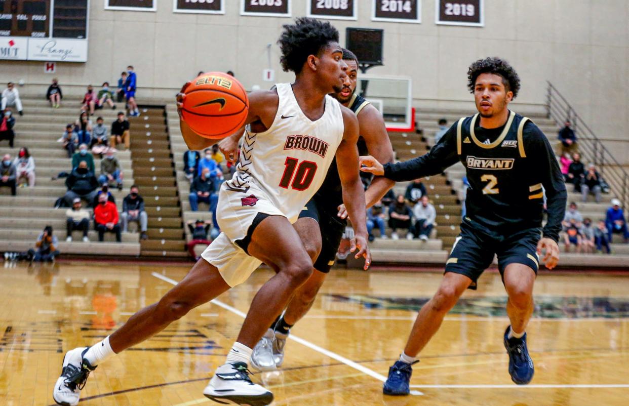 Brown freshman Kino Lilly Jr. drives to the basket to put Brown ahead in the first quarter. Bryant's Erickson Bans is defending.