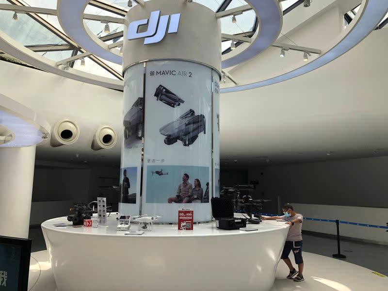 Man wearing a face mask following the coronavirus disease (COVID-19) outbreak is seen at a counter displaying drones and other products at DJI's flagship store in Shenzhen