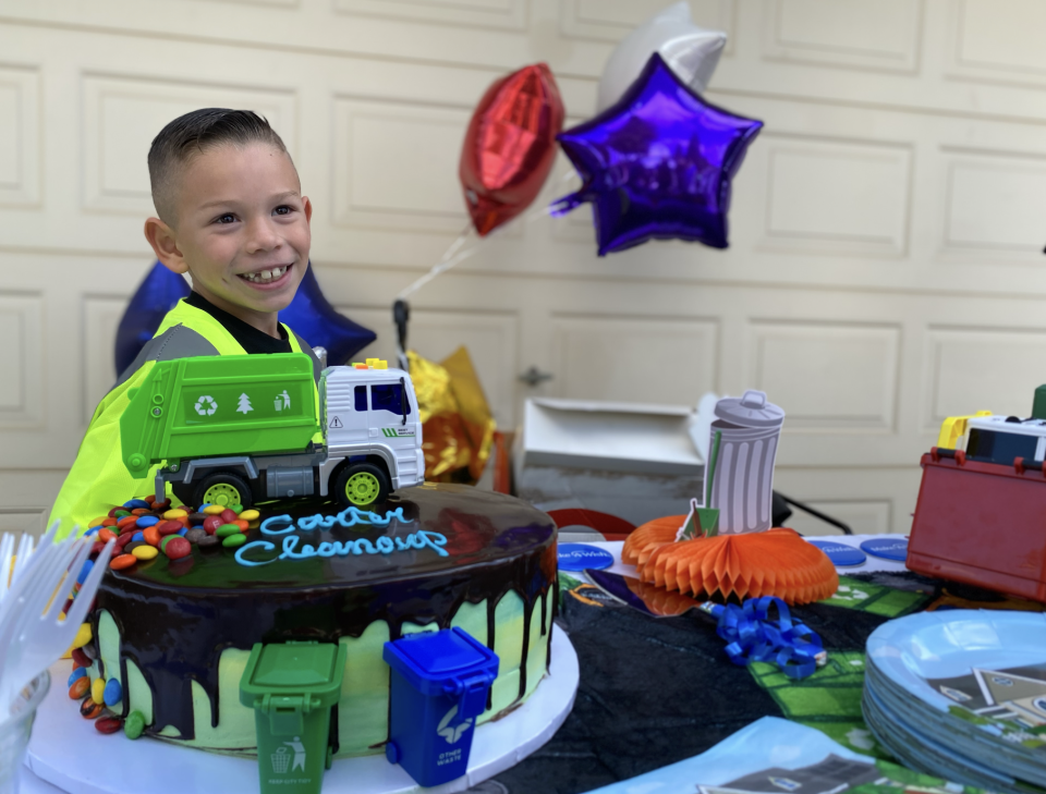 Surrounded by gifts and a garbage collection-themed cake, Carter Gomes, 7, smiles as the Make-A-Wish Foundation granted him his wish of becoming a garbage man for a day in Turlock, California.