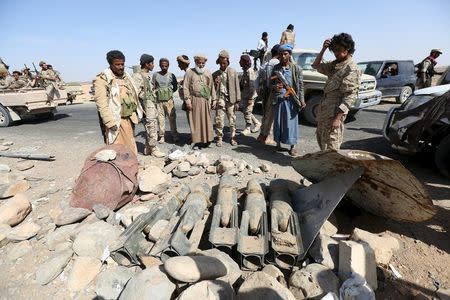 Tribal fighters loyal to Yemen's President Abd-Rabbu Mansour Hadi look at shells left behind by Houthi rebels in Majaz district, Yemen's northwestern province of Marib, after the pro-Hadi forces took the area from Houthi rebels, December 18, 2015. REUTERS/Ali Owidha