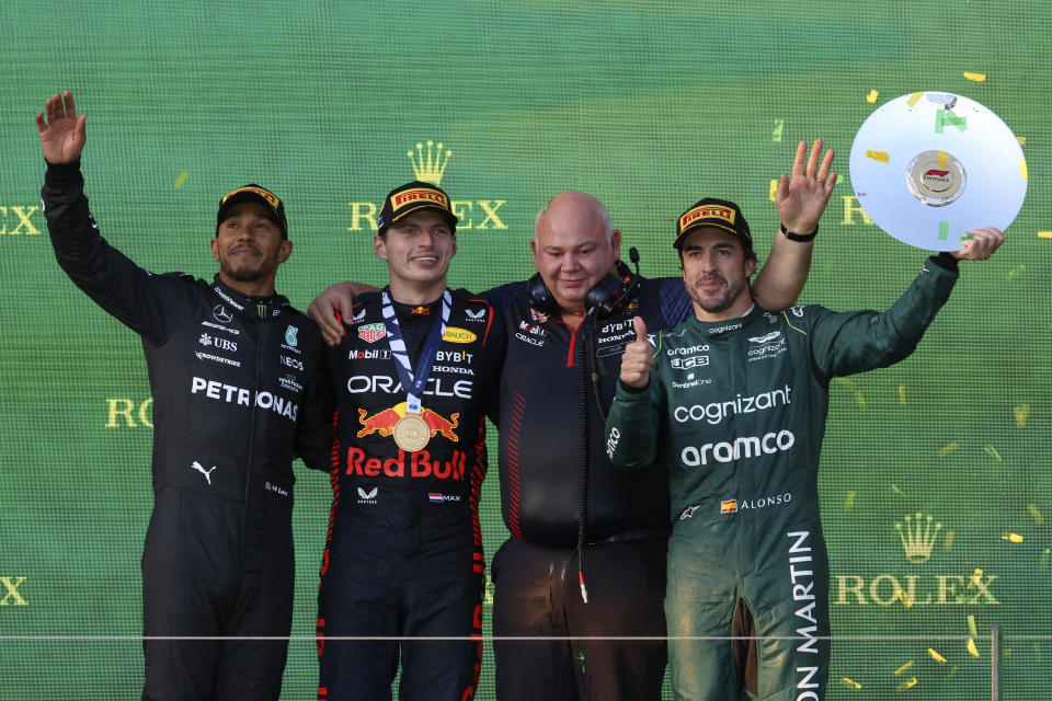 Mercedes driver Lewis Hamilton of Britain, left, Red Bull driver Max Verstappen of Netherlands, second left, Rob Marshall the chief engineering of Red Bull and Aston Martin driver Fernando Alonso of Spain, right, stand on the podium after the Australian Formula One Grand Prix at Albert Park in Melbourne, Sunday, April 2, 2023. Verstappen won the race while Hamilton came 2nd and Alonso took 3rd. (AP Photo/Asanka Brendon Ratnayake)