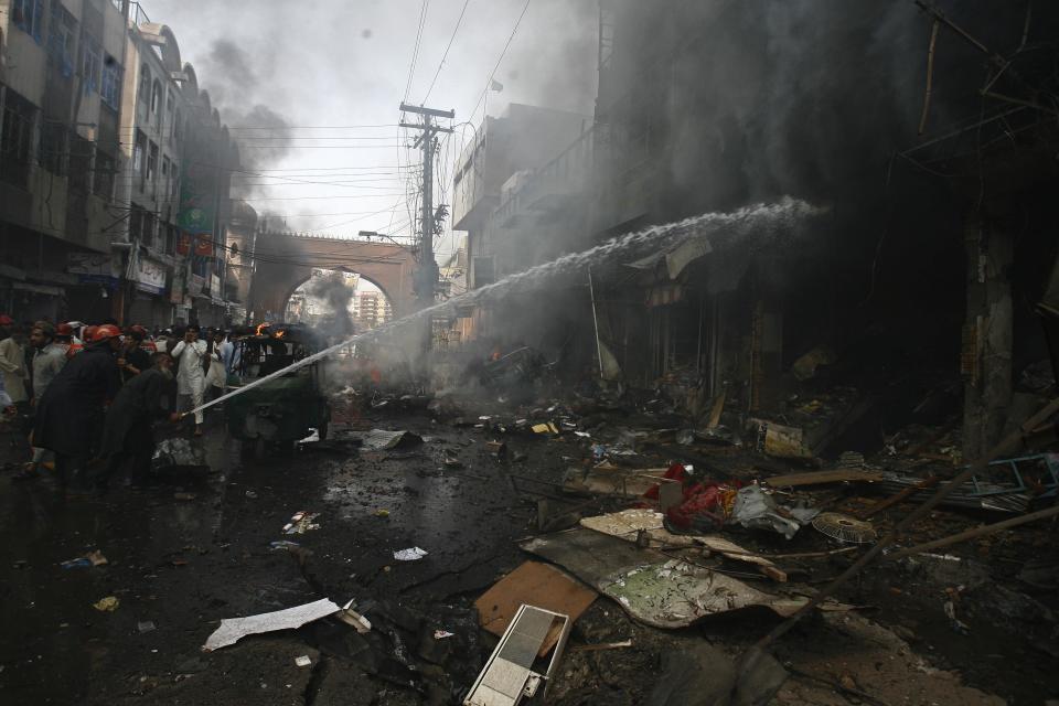 Firefighters extinguish a fire at the site of a bomb attack in Peshawar September 29, 2013. Twin blasts in the northwestern Pakistan city of Peshawar killed 33 people and wounded 70 on Sunday, a week after two bombings at a church in the frontier city killed scores, police and hospital authorities said. REUTERS/Khuram Parvez (PAKISTAN - Tags: POLITICS CIVIL UNREST CRIME LAW)