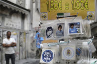 Stickers of soccer legend and former Napoli player Diego Armando Maradona are on sale, in downtown Naples, Italy, Wednesday, Sept. 18, 2019. Maradona achieved some of his most memorable exploits and in Naples is still revered with god-like status.(AP Photo/Gregorio Borgia)