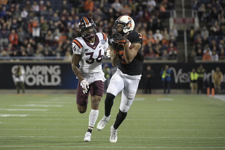 Oklahoma State wide receiver Marcell Ateman (3) runs after catching a pass in front of Virginia Tech cornerback Adonis Alexander (36) during the first half of the Camping World Bowl NCAA college football game Thursday, Dec. 28, 2017, in Orlando, Fla. (AP Photo/Phelan M. Ebenhack)