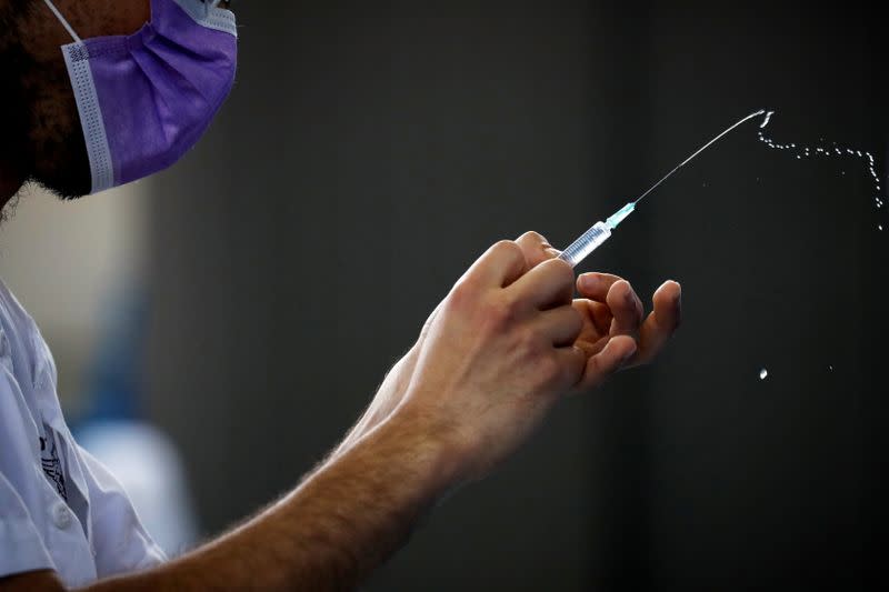 FILE PHOTO: A medical worker prepares to administer a vaccination against the coronavirus disease (COVID-19) at a temporary Clalit Healthcare Maintenance Organization (HMO) centre, at a sports hall in Netivot