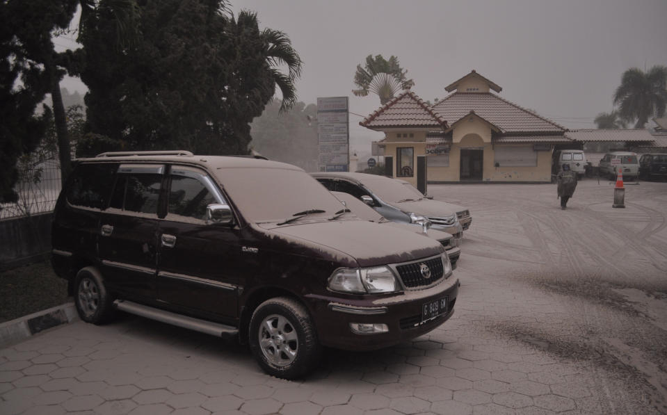 Vehicles are covered with volcanic ash from an eruption of Mount Kelud, in Yogyakarta, Indonesia, Friday, Feb. 14, 2014. Volcanic ash from a major eruption in Indonesia shrouded a large swath of the country's most densely populated island on Friday, closed three international airports and sent thousands fleeing. (AP Photo/Slamet Riyadi)