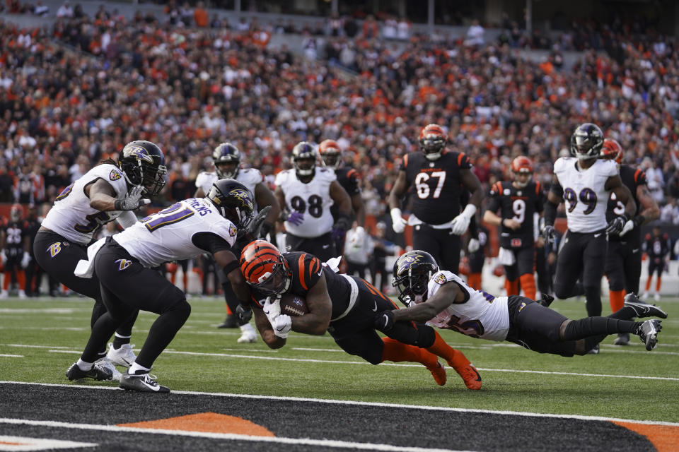 Cincinnati Bengals' Joe Mixon (28) dives in for a touchdown while being tackled by Baltimore Ravens' Tavon Young (25) during the first half of an NFL football game, Sunday, Dec. 26, 2021, in Cincinnati. (AP Photo/Jeff Dean)