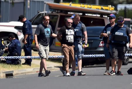 Police lead a handcuffed man away from the scene of a shooting in the western Sydney suburb of Ingleburn, Australia, March 7, 2016. REUTERS/Dan Himbrechts/AAP