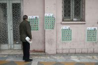 A man looks at parliamentary election campaign posters in Tehran