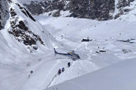 In this Saturday, Jan. 18, 2020 photo, trekkers are being rescued in a helicopter a day after an avalanche hit Mount Annapurna trail in Nepal. Special army and government rescue personnel were searching again on Monday for four South Korean trekkers and their three Nepali guides lost since an avalanche swept a popular trekking route in Nepal's mountains. (AP Photo/Phurba Ongel Sherpa)