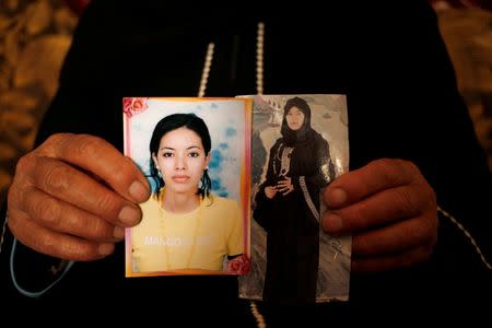 Chahla, 66, shows photographs of her daughter Wahida, who was married to a militant killed in an air strike and is now being held with her son in a prison in Tripoli, during a meeting with Reuters in El Kef, Tunisia June 1, 2016. Picture taken June 1, 2016. REUTERS/Zohra Bensemra