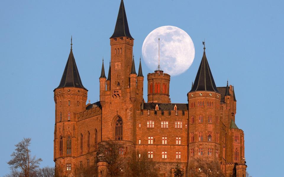 The full moon rise above Hohenzollern castle in Hechingen, Germany - SHUTTERSTOCK