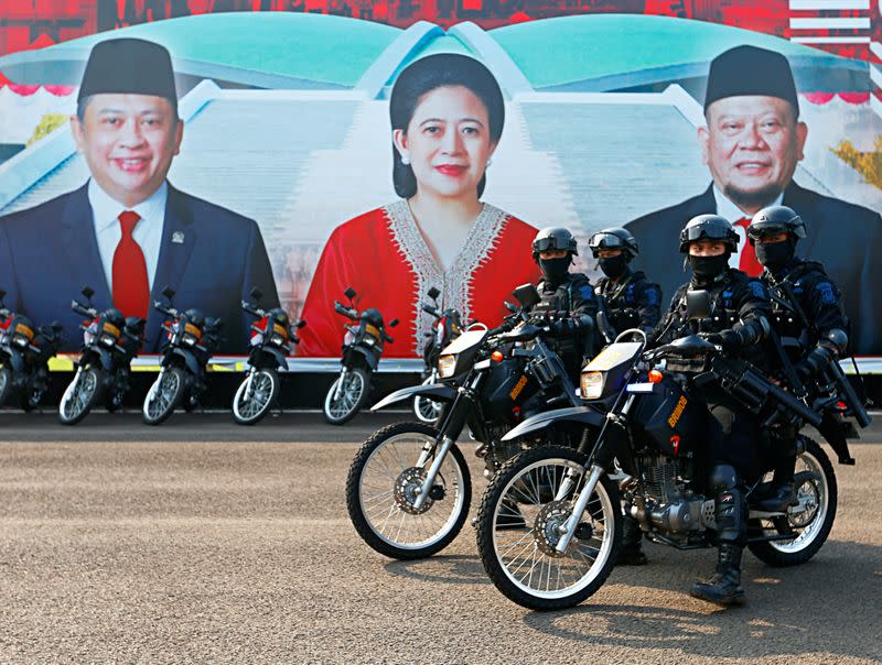 Riot police ride motorbikes while guarding the Indonesian Parliament building in Jakarta