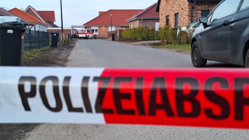 Emergency services stand behind a cordon. The police are investigating after shots were fired in the district of Rotenburg. There are two crime scenes - one in a detached house in Westervesede in the municipality of Scheessel and another in Bothel in the district of Rotenburg. Kai Moorschlatt/NordwestMedia TV/dpa