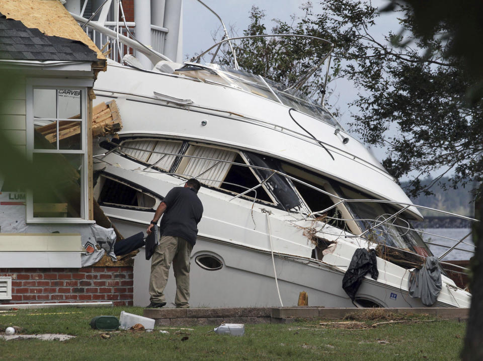 <p>An insurance adjuster looks over a storm beached yacht off of East Front Street in New Bern, N.C., Thursday, September 20, 2018. Hurricane Florence brought damaging winds and destructive flooding to the neighborhood fronting the Neuse River. (Gray Whitley/Sun Journal via AP) </p>