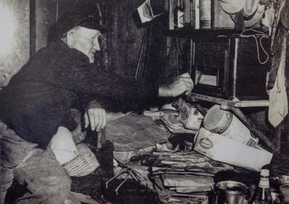 Photographs and personal items from the cabin of Teddy Tollefsen are on display in the nature and welcome center at St. Andrews State Park. Tollefsen took apart his shipwrecked boat and built a cabin at the park before it was a park, living there for 25 years as a hermit. In the photo, Tollefsen works his battery-operated radio inside his cabin.