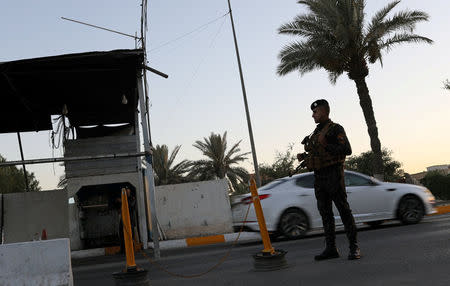 FILE PHOTO: An Iraqi policeman stands guard at a check point in Baghdad, Iraq June 20, 2018. REUTERS/Thaier Al-Sudani/File Photo