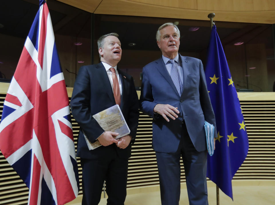 FILE - In this Monday, March 2, 2020 file photo, EU chief negotiator Michel Barnier, right, speaks with Britain's chief negotiator David Frost prior to the start of the first round of post -Brexit trade talks between the EU and the UK, at EU headquarters in Brussels. Britain and the European Union have struck a provisional free-trade agreement that should avert New Year chaos for cross-border traders and bring a measure of certainty for businesses after years of Brexit turmoil. (Olivier Hoslet, Pool via AP, File)