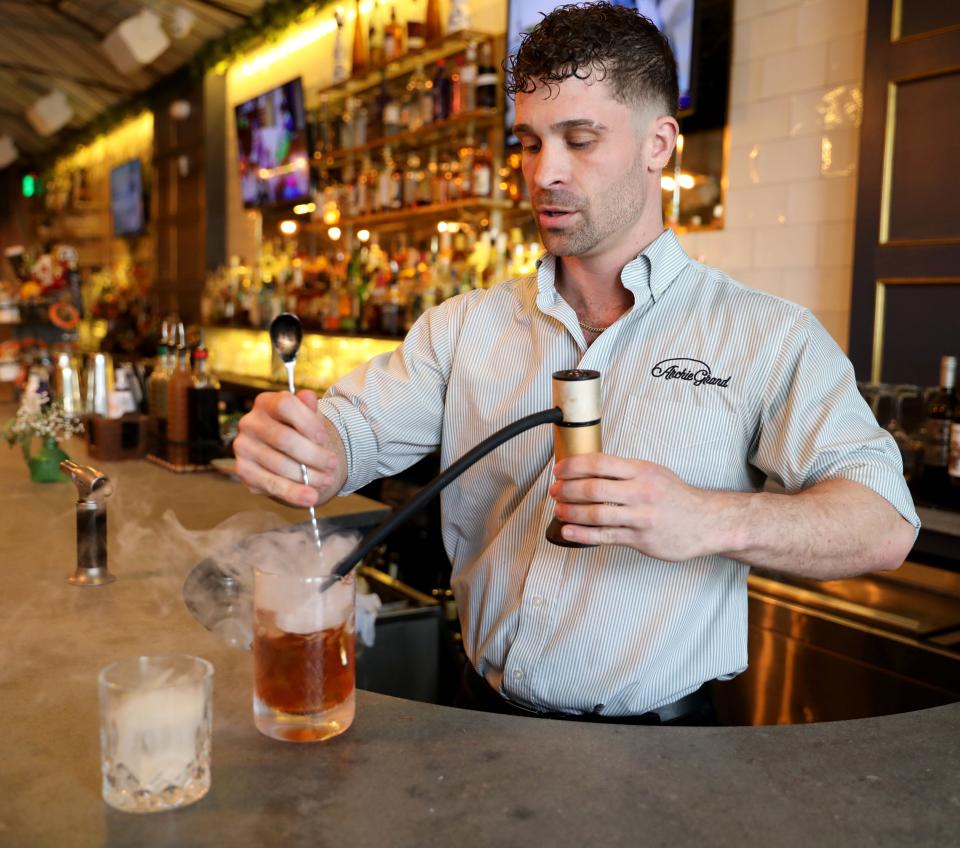 The Good Ol' Smokey, an Old Fashioned cocktail is prepared by bartender Tommy Quintano at Archie Grand on Mamaroneck Avenue in White Plains, May 13, 2022. He infuses the glass with some smoke before completing the drink. 