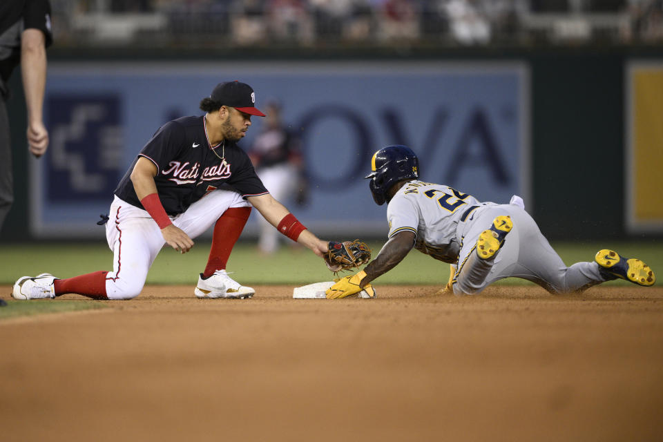 Milwaukee Brewers' Andrew McCutchen, right, steals second against Washington Nationals shortstop Luis Garcia during the fourth inning of a baseball game Friday, June 10, 2022, in Washington. (AP Photo/Nick Wass)