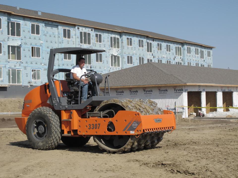 Pete Kelsch, who operates heavy equipment for an excavation company, waits for a grader to pass by at an apartment construction site in northeast Bismarck, N.D., on Tuesday, Sept. 25, 2012. A new report predicts demand for housing in North Dakota will skyrocket in the next 15 years, the result of the state's oil-fueled economic prosperity. (AP Photo/Dale Wetzel)