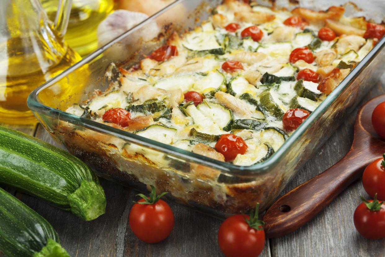 Baked zucchini with chicken, cherry tomatoes and herbs in a glass pot